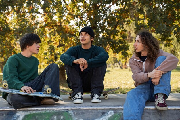 Freunde sitzen in der Vorderansicht des Skateparks