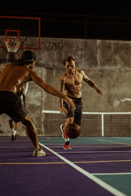 Freunde spielen Basketball. Junge Männer spielen Basketball auf der Straße.