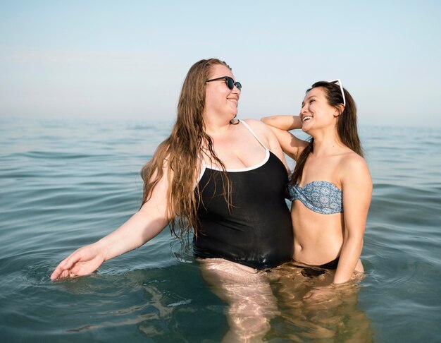 Freunde stehen im Wasser und schauen sich an