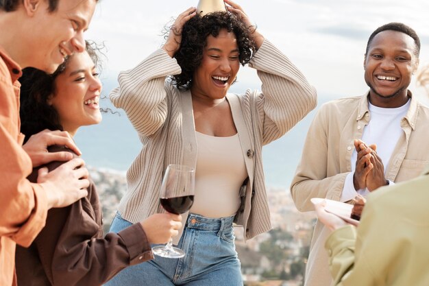 Freunde trinken Wein und essen Kuchen während der Party im Freien