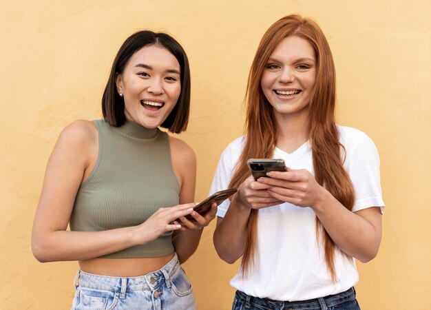 Kostenloses Foto freunde überprüfen ihre telefone im freien