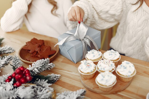 Freunde verbrachten Zeit zu Hause. Zwei Mädchen mit Weihnachtsgeschenk. Frau in einer Weihnachtsmütze.