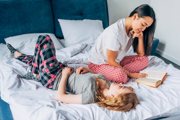 Freundinnen, die auf Bett stillstehen