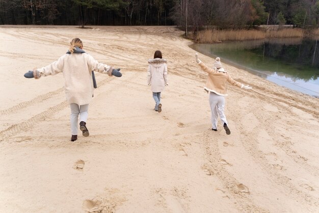 Freundinnen, die auf Reisen am Strand spazieren gehen