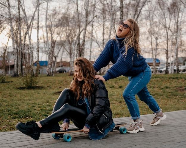 Freundinnen, die Spaß im Freien mit Skateboards haben