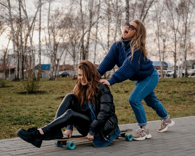 Freundinnen, die Spaß im Freien mit Skateboards haben