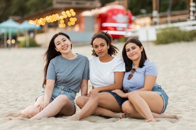 Freundinnen, die zusammen am Strand posieren