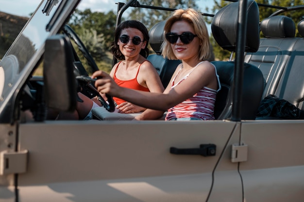 Kostenloses Foto freundinnen mit sonnenbrille, die mit dem auto reisen