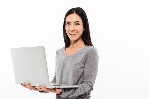 Freundliche Frau, die Laptop-Computer verwendet.