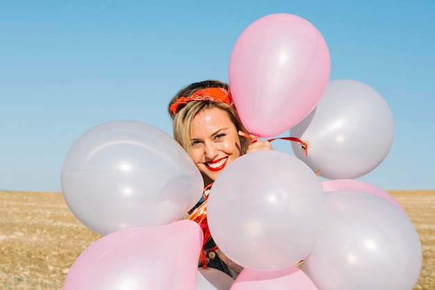 Freundliche frau, die mit ballonen aufwirft