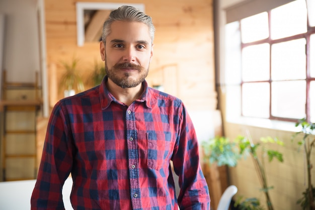 Kostenloses Foto freundlicher unternehmer, der im modernen büro aufwirft