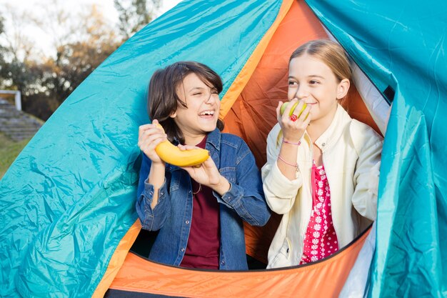 Freundliches Mädchen, das einen Apfel Riechen