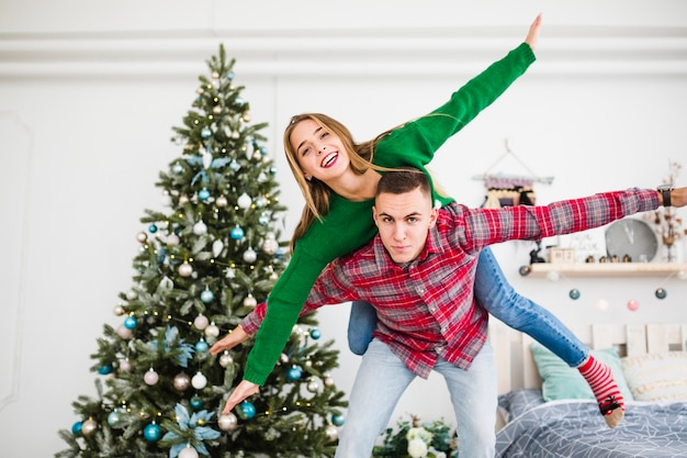 Freundliches Paar nahe bei Weihnachtsbaum