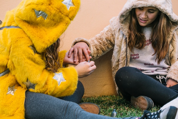 Freundschaftskonzept mit zwei Mädchen, die Nägel polieren