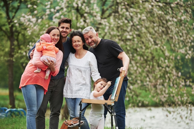 Freut mich, einander zu sehen. Familie haben gute Zeit in der Parklandschaft. Junger Maler, der das Zeichnen lehrt