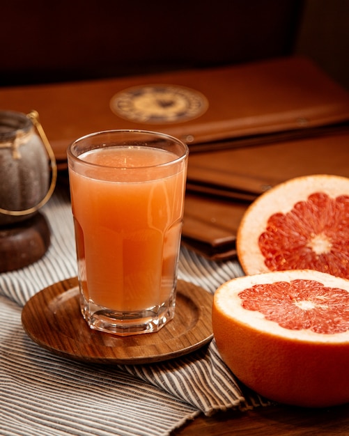 Kostenloses Foto frisch gepresster grapefruitsaft mit grapefruitscheiben