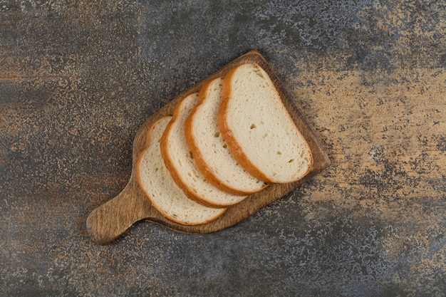 Kostenloses Foto frisch geschnittenes brot auf holzbrett.