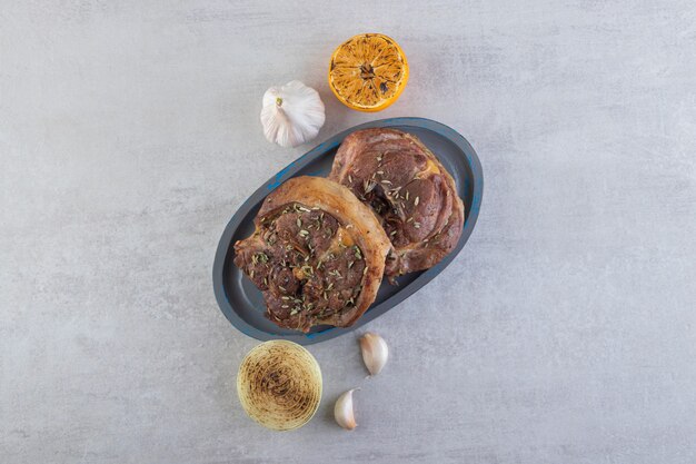 Frisch geschnittenes Fleisch mit frischem Gemüse auf einem Steintisch.