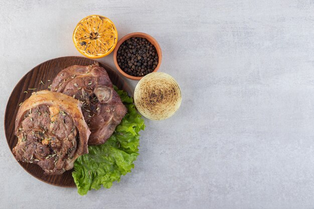 Frisch geschnittenes Fleisch mit frischem Gemüse auf einem Steintisch.