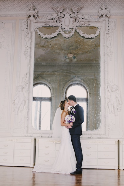 Kostenloses Foto frisch verheiratet küssen vor einem spiegel