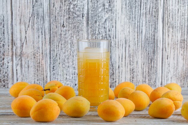 Frische Aprikosen mit eisiger Saft-Seitenansicht auf einem Holztisch