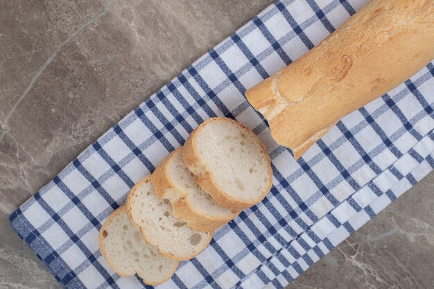 Frische Baguettescheiben auf blauer Tischdecke. Hochwertiges Foto