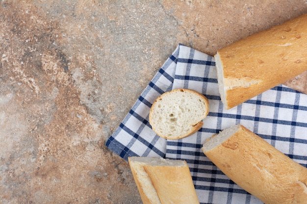 Frische Baguettescheiben auf gestreifter Tischdecke