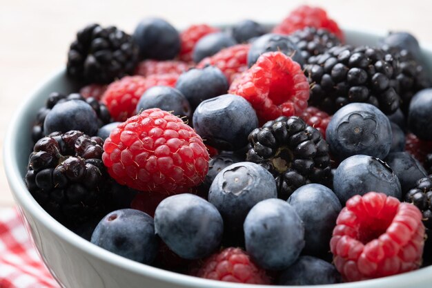 Frische Beeren in einer Schüssel auf einem Holztisch