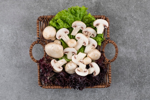 Kostenloses Foto frische bio-pilze mit salat im korb.