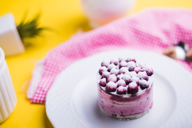 Frische Blaubeeren auf weißer Platte gegen gelben Hintergrund