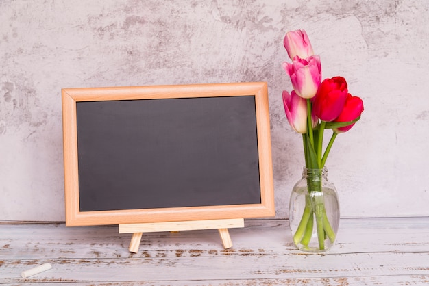 Frische Blumen auf Stielen in Vase und Tafel