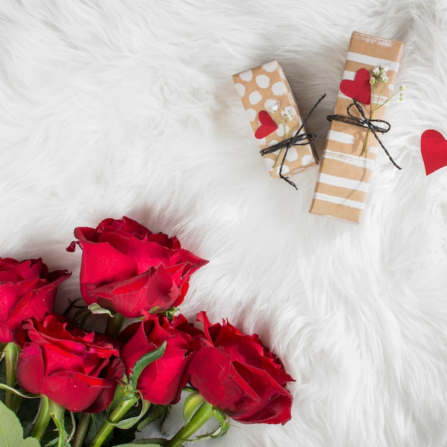 Frische Blumen und Geschenke mit Ornament Herzen auf Wolldecke