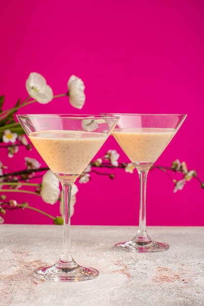 Frische cocktails der vorderansicht mit blumen auf lila oberfläche