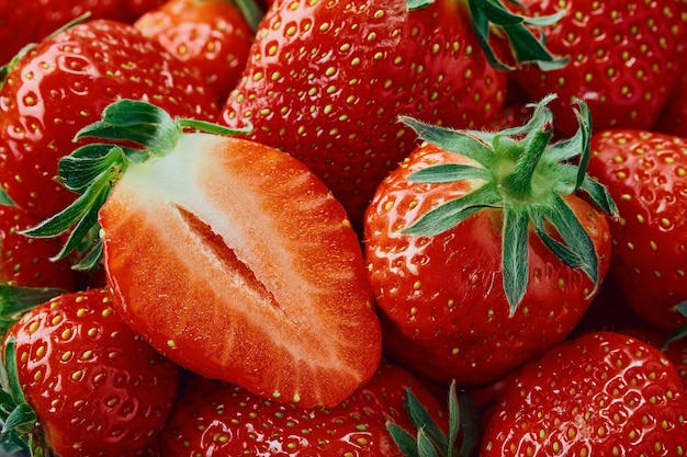 Frische Erdbeeren Eine halbe Erdbeere und eine ganze Beere closeup Hintergrund von reifen Erdbeeren köstliches natürliches Dessert