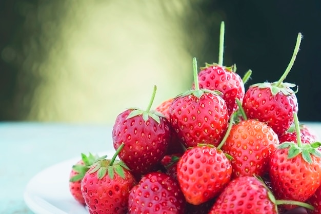 Frische Erdbeeren über goldenem Steigungslichthintergrund