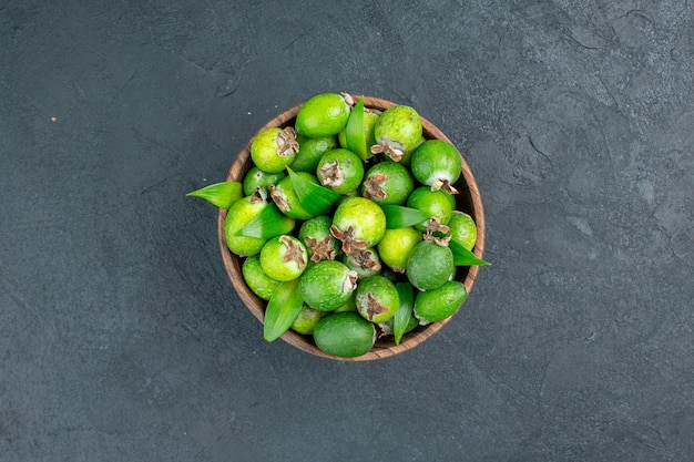 Frische Feijoas der Draufsicht in der dunklen Oberfläche des Eimers mit Kopierraum