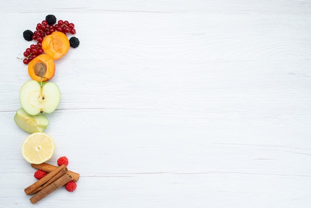 Frische geschnittene Früchte der Draufsicht frisch bunt und reif mit Zimt auf dem weißen Hintergrundfruchtfarbfutterfoto