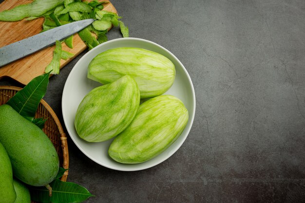 Frische grüne Mango auf dunkler Oberfläche