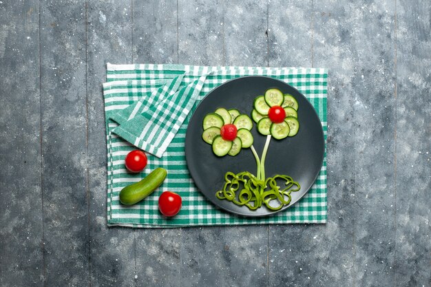 Frische Gurkenblume der Draufsicht gestaltete Salat auf Grauzone