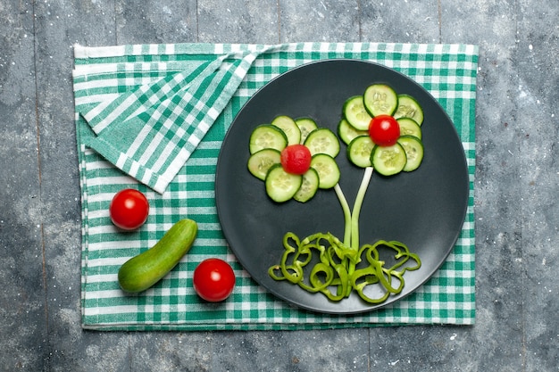 Frische Gurkenblume der Draufsicht gestaltete Salat auf Grauzone