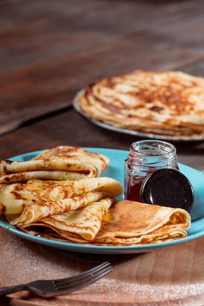 Frische hausgemachte französische Crepes mit Eiern, Milch und Mehl, gefüllt mit Marmelade auf einem Vintage-Teller