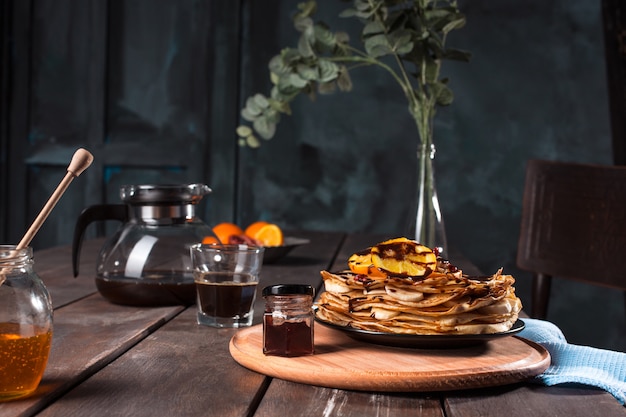 Frische hausgemachte französische Crepes mit Eiern, Milch und Mehl, gefüllt mit Marmelade auf einem Vintage-Teller