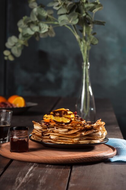 Frische hausgemachte französische Crepes mit Eiern, Milch und Mehl, gefüllt mit Marmelade auf einem Vintage-Teller