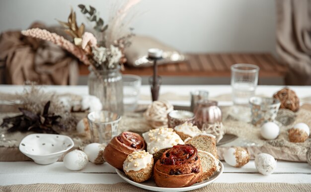 Frische hausgemachte Osterbackwaren auf dem Feiertagstisch mit Dekordetails auf unscharfem Hintergrund.