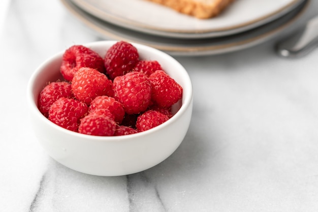 Frische himbeeren auf dem tisch zum frühstück