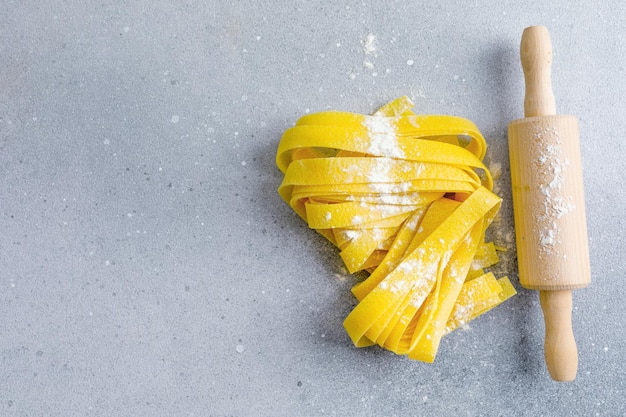 Frische italienische pasta papardelle mit mehl auf hellem hintergrund draufsicht bäckereikonzept