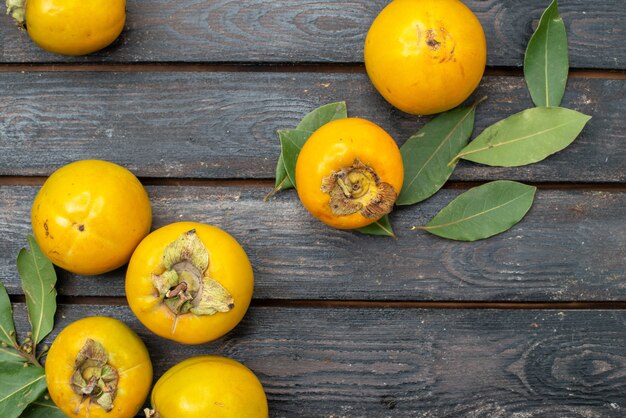 Frische Kakis der Draufsicht auf rustikalem Holztisch, Frucht reif weich