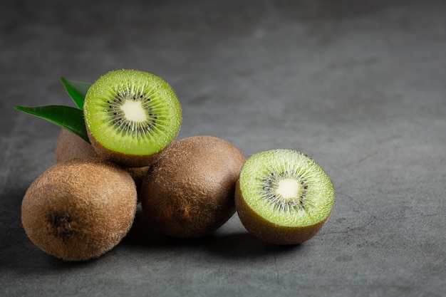 Frische Kiwi, halbiert, auf dunklen Boden legen