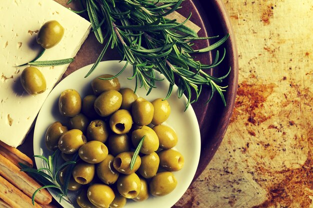 Frische, leckere griechische grüne Oliven mit Käsefeta oder Ziegenkäse. Nahansicht. Mediterranes Essen.Toning.