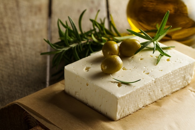 Frische, leckere griechische grüne Oliven mit Käsefeta oder Ziegenkäse. Nahansicht. Mediterranes Essen.